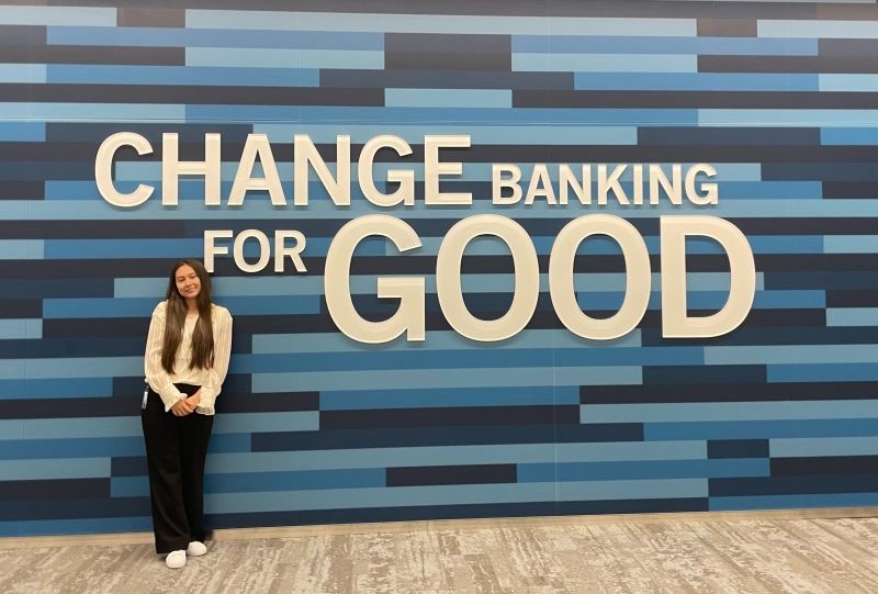 Mary standing next to wall with slogan 'Changing Banking For Good'